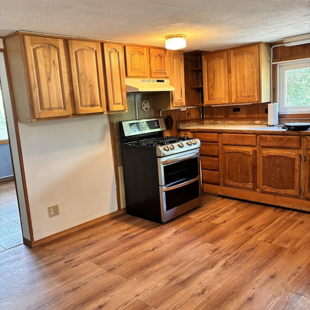10279 N Sherman Rd, Frederic, MI 49733 - kitchen with range with two ovens, under cabinet range hood, a textured ceiling, open shelves, and light wood-style flooring