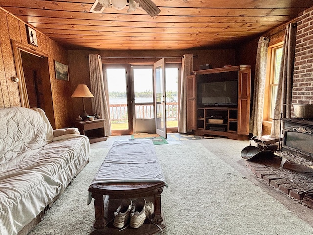 1950 Highbank Trl, Lewiston, MI 49756 - carpeted living room featuring wooden ceiling, french doors, ceiling fan, a wood stove, and wood walls