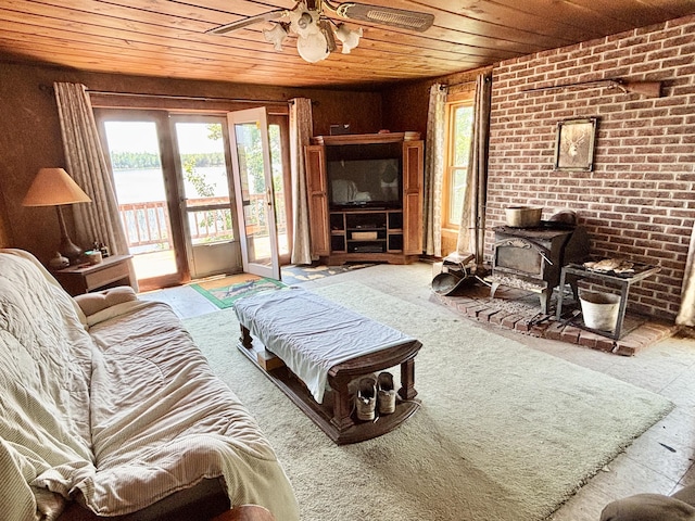 1950 Highbank Trl, Lewiston, MI 49756 - living room with wooden ceiling, a wood stove, ceiling fan, and brick wall