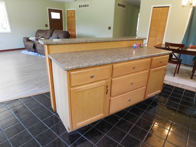 4616 Martin Dr, Frederic, MI 49733 - kitchen with dark tile patterned flooring, a center island, light brown cabinetry, light countertops, and open floor plan