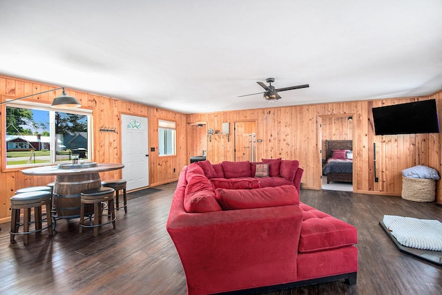 2145 Mustang St, Saint Helen, MI 48656 - living room with healthy amount of natural light, wooden walls, a ceiling fan, and dark wood-type flooring