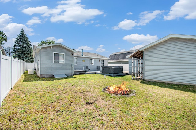 2145 Mustang St, Saint Helen, MI 48656 - back of property featuring a hot tub, a fenced backyard, and a fire pit