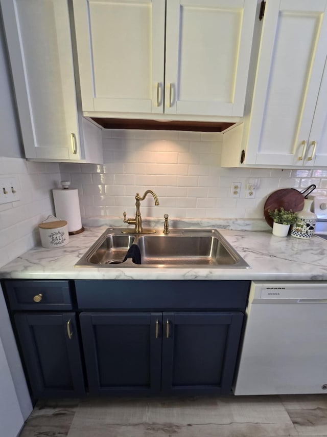 506 S N St, Alpena, MI 49707 - kitchen with white dishwasher, tasteful backsplash, light stone counters, and blue cabinets