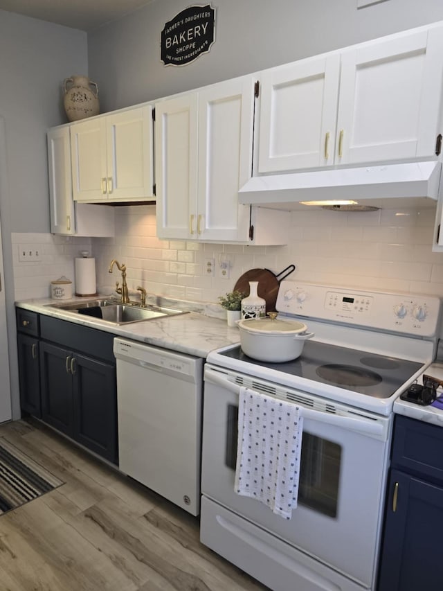 506 S N St, Alpena, MI 49707 - kitchen featuring white appliances, light wood finished floors, white cabinetry, light countertops, and backsplash