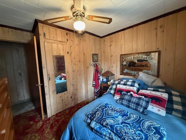 119 Ethel Dr, Roscommon, MI 48653 - bedroom with wood walls, carpet, crown molding, and a ceiling fan