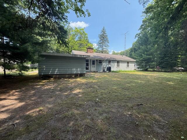 119 Ethel Dr, Roscommon, MI 48653 - back of house featuring a chimney