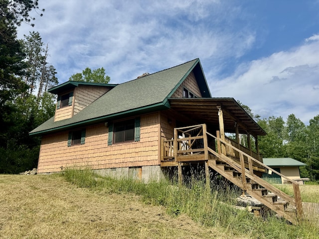 5283 Griffin Rd, Lewiston, MI 49756 - view of side of property with a shingled roof, stairway, and crawl space