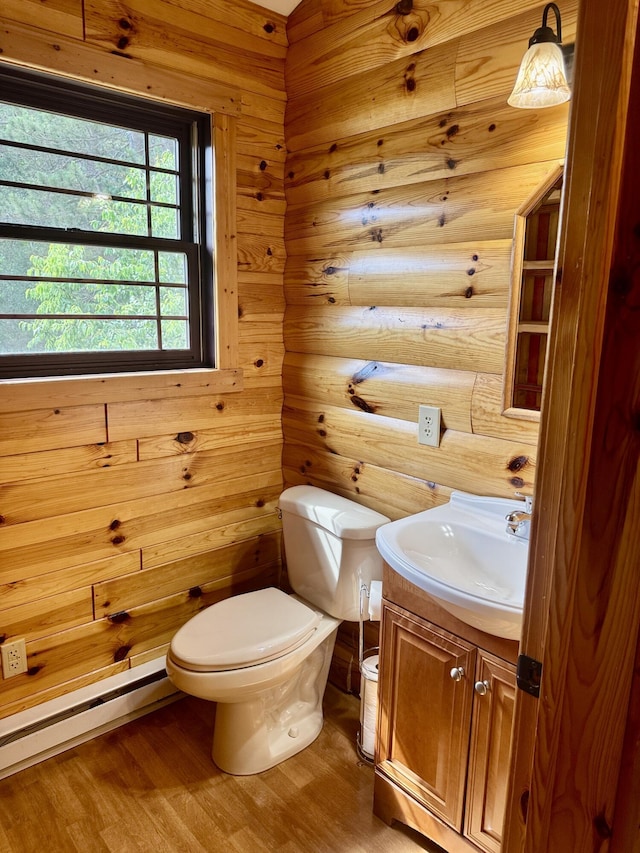 5283 Griffin Rd, Lewiston, MI 49756 - half bathroom with vanity, wood finished floors, and a baseboard heating unit