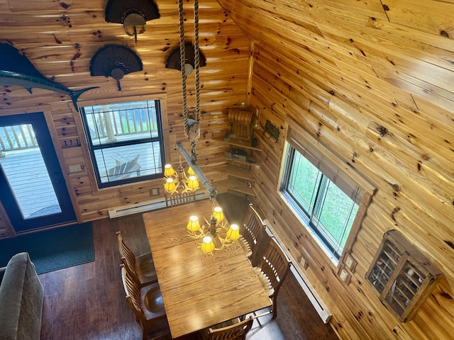 5283 Griffin Rd, Lewiston, MI 49756 - dining room with a baseboard heating unit, wood finished floors, high vaulted ceiling, wood walls, and a chandelier