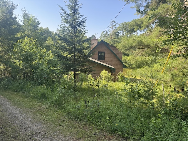 5283 Griffin Rd, Lewiston, MI 49756 - view of side of property with a chimney and a forest view