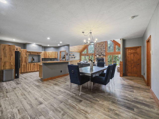 6552 High Trees Ct, Gaylord, MI 49735 - dining room featuring light wood finished floors, a chandelier, a textured ceiling, recessed lighting, and vaulted ceiling