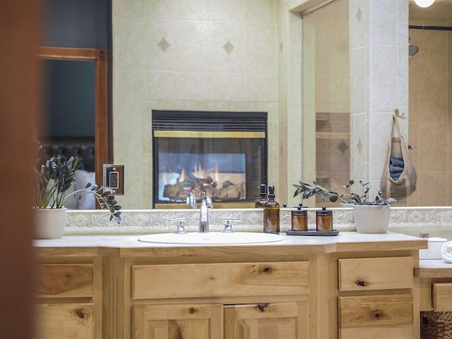 6552 High Trees Ct, Gaylord, MI 49735 - bathroom featuring vanity, decorative backsplash, and a tiled fireplace