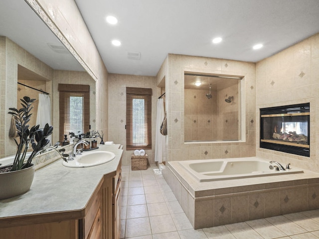 6552 High Trees Ct, Gaylord, MI 49735 - full bath featuring tile patterned flooring, a garden tub, tile walls, a tile shower, and a tiled fireplace