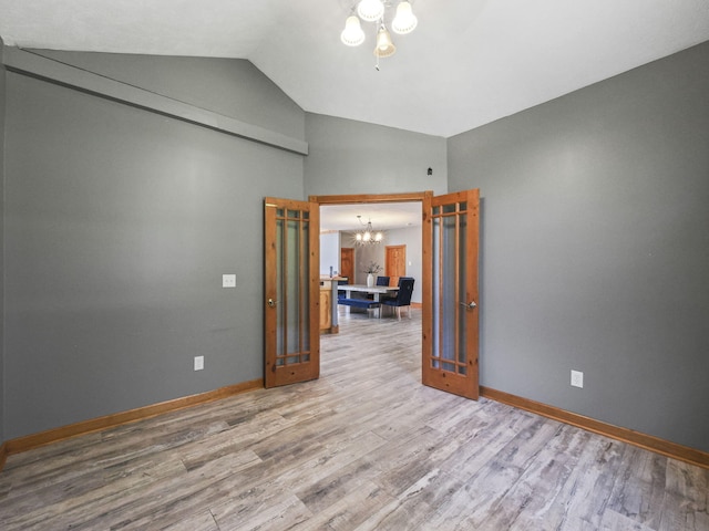 6552 High Trees Ct, Gaylord, MI 49735 - unfurnished room with a chandelier, wood finished floors, and high vaulted ceiling