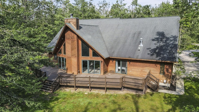 6552 High Trees Ct, Gaylord, MI 49735 - rear view of property featuring a lawn, a chimney, a wooden deck, roof with shingles, and view of scattered trees
