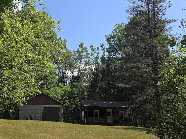 899 Bills Rd, Mio, MI 48647 - log-style house featuring a front yard and a garage