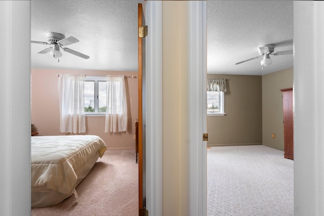 2829 Kassuba Rd, Gaylord, MI 49735 - carpeted bedroom featuring a textured ceiling, multiple windows, and ceiling fan