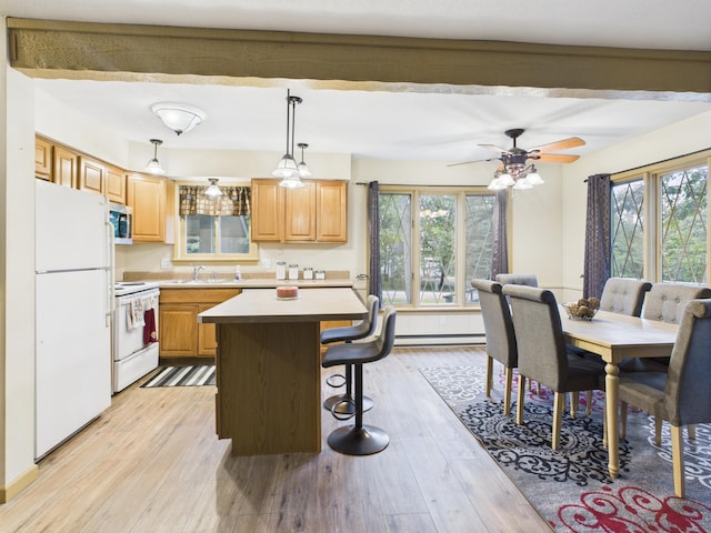 5589 Algonquin Rd, Gaylord, MI 49735 - kitchen featuring white appliances, a baseboard radiator, healthy amount of natural light, and a breakfast bar area