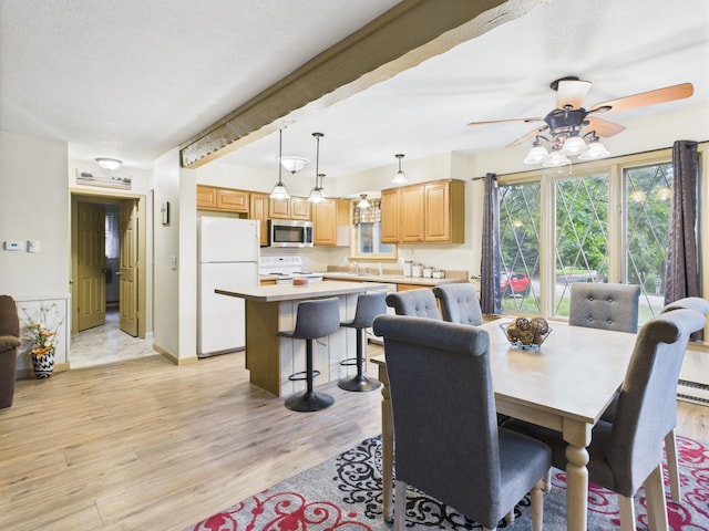 5589 Algonquin Rd, Gaylord, MI 49735 - dining space featuring light wood-type flooring, a ceiling fan, and beam ceiling