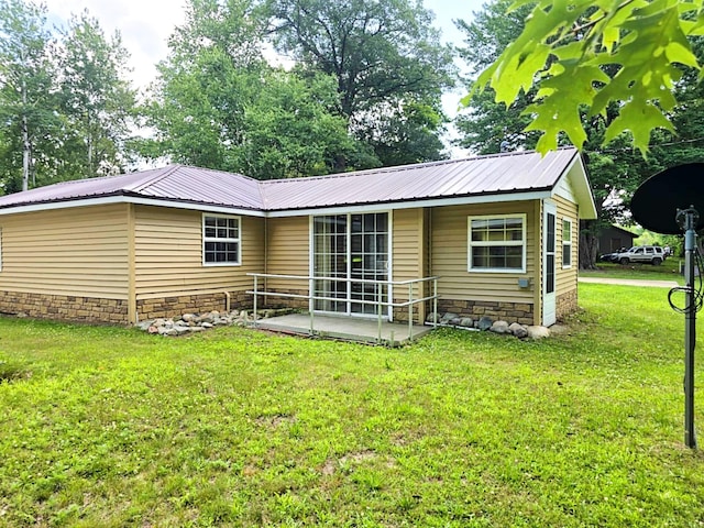 6416 Jimary Ln, Gladwin, MI 48624 - back of house with a yard, a metal roof, and a patio area