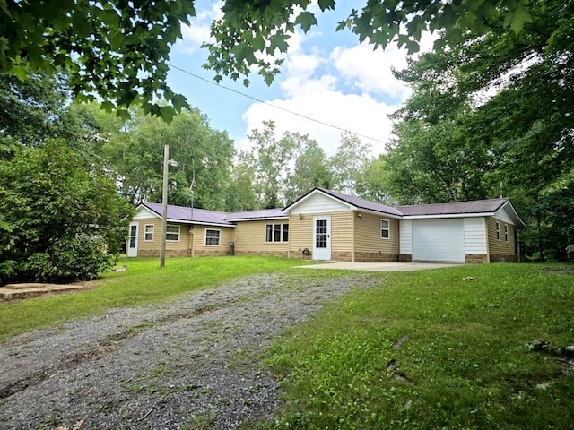 6416 Jimary Ln, Gladwin, MI 48624 - ranch-style home with driveway, a front yard, a metal roof, and a garage