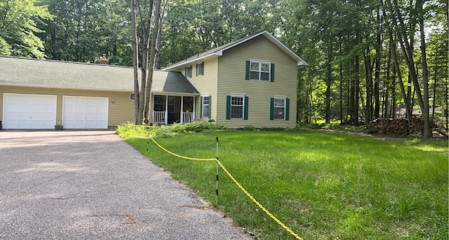 6119 W Nestel Rd, Houghton Lake, MI 48629 - view of front facade with asphalt driveway, a garage, and a front lawn
