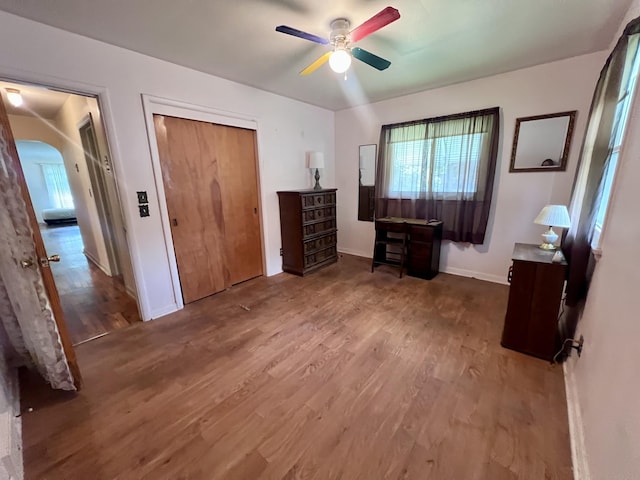 1003 Ada St, Owosso, MI 48867 - bedroom with wood finished floors, multiple windows, arched walkways, and a closet