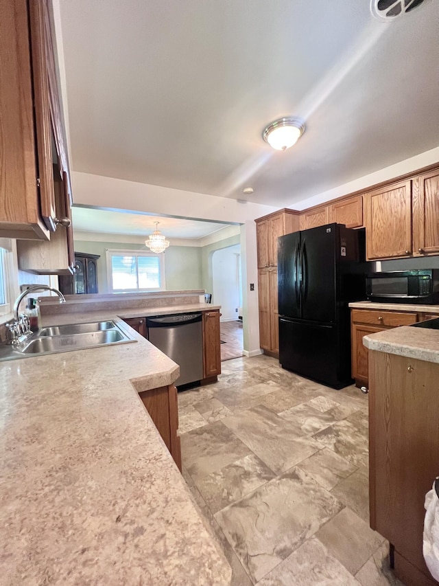 1003 Ada St, Owosso, MI 48867 - kitchen featuring black appliances, a peninsula, light countertops, brown cabinetry, and a chandelier