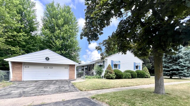 1003 Ada St, Owosso, MI 48867 - ranch-style house featuring brick siding, a detached garage, and an outbuilding