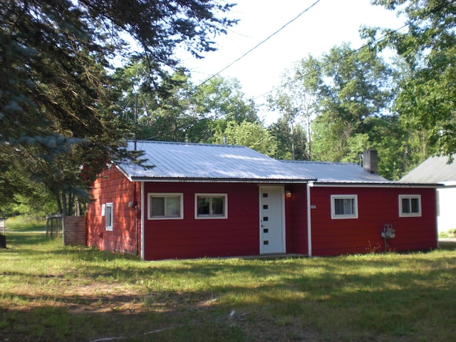 557 Davis St, Lake, MI 48632 - view of front of house with a front yard, a chimney, and a metal roof