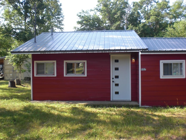 557 Davis St, Lake, MI 48632 - view of front of home with a front lawn, a metal roof, and an outbuilding