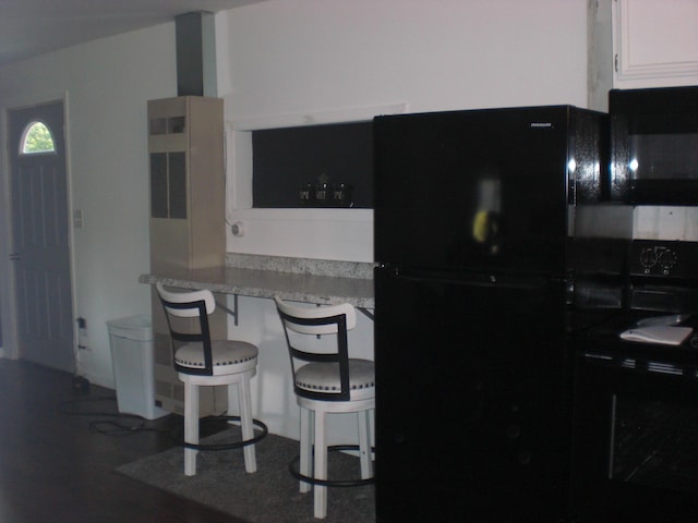 557 Davis St, Lake, MI 48632 - kitchen with freestanding refrigerator, a kitchen bar, white cabinetry, and light countertops