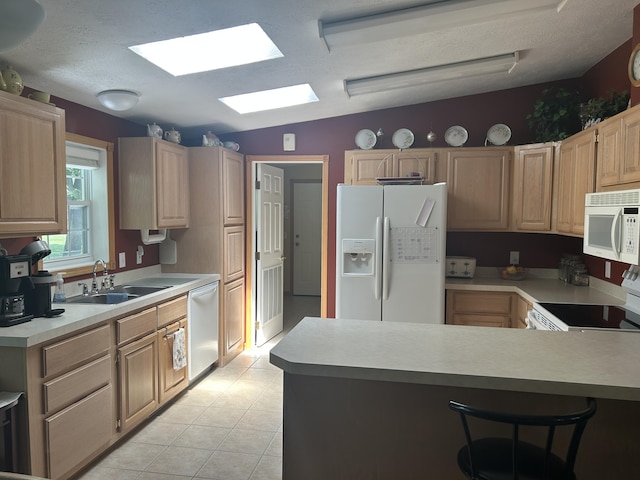 362 N Addison St, Alpena, MI 49707 - kitchen featuring white appliances, light countertops, light brown cabinets, a peninsula, and a breakfast bar area