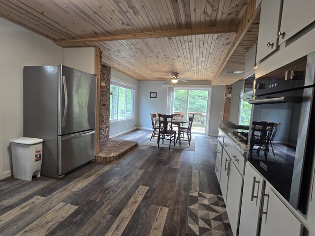 1300 Geesey Ave, Mio, MI 48647 - kitchen with appliances with stainless steel finishes, dark wood-style floors, white cabinetry, ceiling fan, and a wooden ceiling with exposed beams