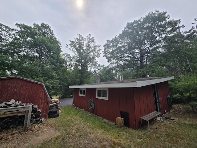 1300 Geesey Ave, Mio, MI 48647 - view of side of property featuring an outbuilding, a chimney, and view of scattered trees