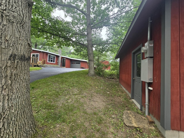 1300 Geesey Ave, Mio, MI 48647 - view of yard featuring a garage and asphalt driveway