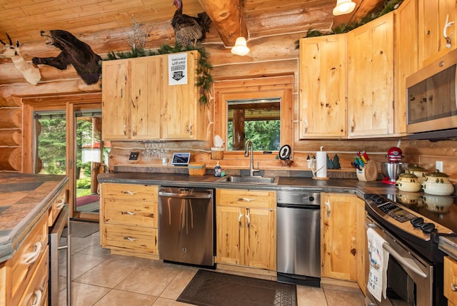 23 Treasure Is, Roscommon, MI 48653 - kitchen with appliances with stainless steel finishes, rustic walls, light tile patterned floors, dark countertops, and light brown cabinets