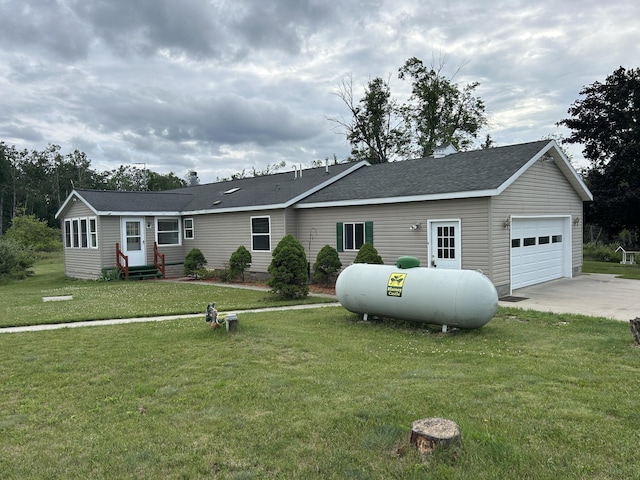 2503 W Hubbard Lake Trl, Hubbard Lake, MI 49747 - ranch-style house with entry steps, concrete driveway, a garage, a front yard, and a shingled roof