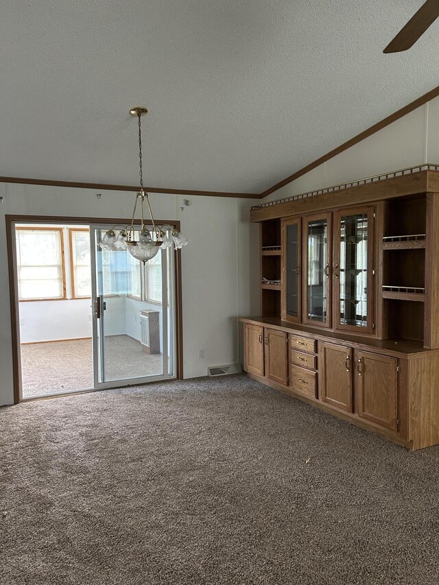 2503 W Hubbard Lake Trl, Hubbard Lake, MI 49747 - carpeted spare room with ornamental molding, a textured ceiling, a chandelier, lofted ceiling, and ceiling fan