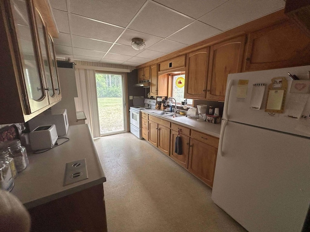 302 S Vine St, Mio, MI 48647 - kitchen featuring white appliances, under cabinet range hood, brown cabinets, light countertops, and a paneled ceiling