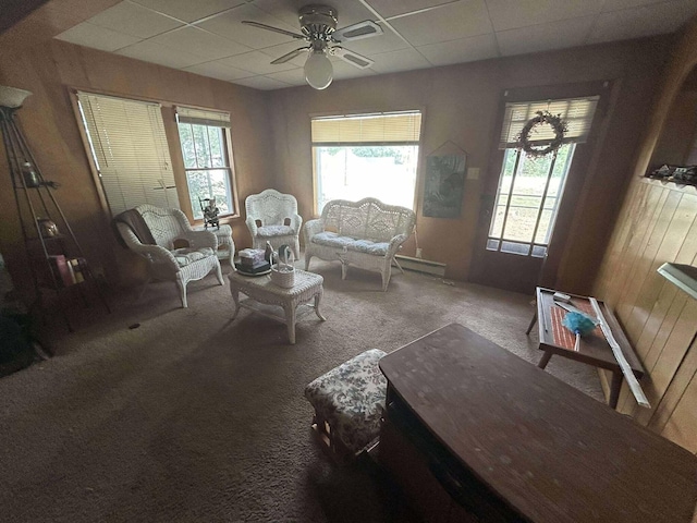 302 S Vine St, Mio, MI 48647 - living room featuring a ceiling fan, carpet, healthy amount of natural light, a paneled ceiling, and wooden walls