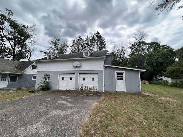 302 S Vine St, Mio, MI 48647 - view of front of home with driveway, an attached garage, and a front lawn