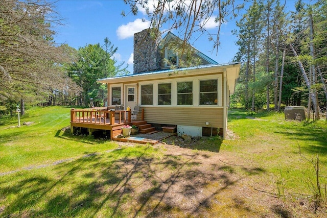 2951 N Palmer Rd, Onaway, MI 49765 - back of property featuring a deck, a lawn, and a chimney