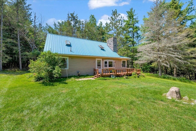 2951 N Palmer Rd, Onaway, MI 49765 - back of house featuring a metal roof, a wooden deck, a yard, and a chimney