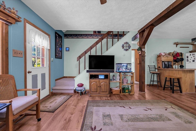 2951 N Palmer Rd, Onaway, MI 49765 - living room featuring stairs, a textured ceiling, and wood finished floors