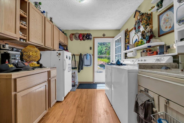 2951 N Palmer Rd, Onaway, MI 49765 - washroom featuring light wood-style flooring, washing machine and dryer, a textured ceiling, and cabinet space