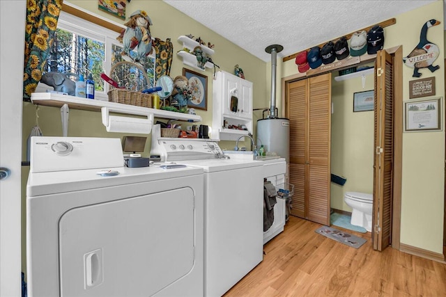 2951 N Palmer Rd, Onaway, MI 49765 - washroom with separate washer and dryer, light wood finished floors, and a textured ceiling