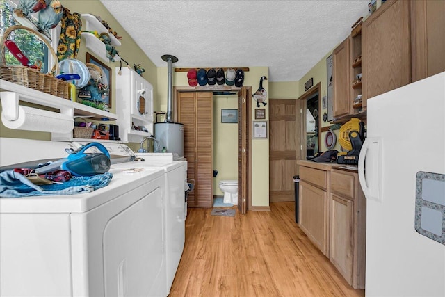 2951 N Palmer Rd, Onaway, MI 49765 - washroom with independent washer and dryer, light wood finished floors, water heater, and a textured ceiling