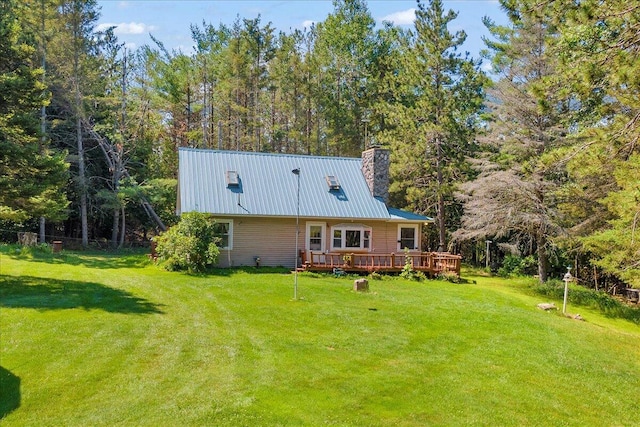 2951 N Palmer Rd, Onaway, MI 49765 - back of house with a metal roof, a chimney, a wooden deck, and a yard