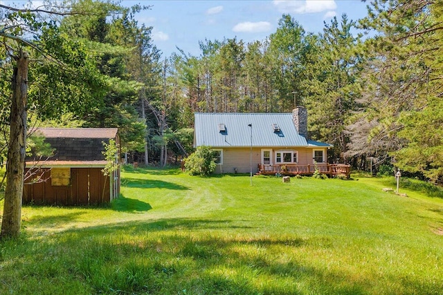 2951 N Palmer Rd, Onaway, MI 49765 - rear view of property with a lawn, a metal roof, a chimney, and a deck